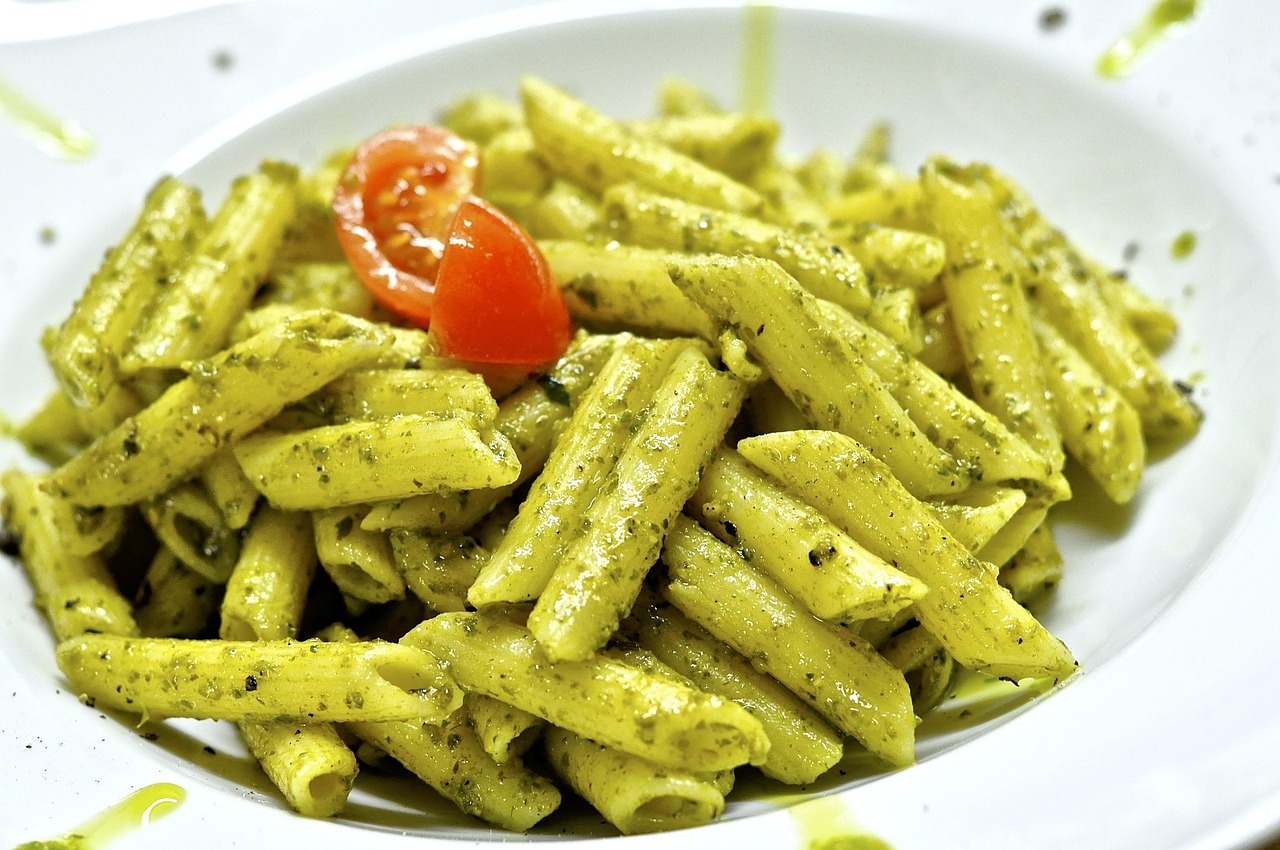 Pasta al pesto servita in un piatto tipico ligure, con basilico fresco e pinoli.