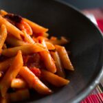 Pasta all'amatriciana servita con guanciale e pecorino, piatto tipico romano.