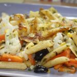 Pasta alla contadina cremosa servita in un piatto decorato, con verdure fresche e una spolverata di parmigiano.