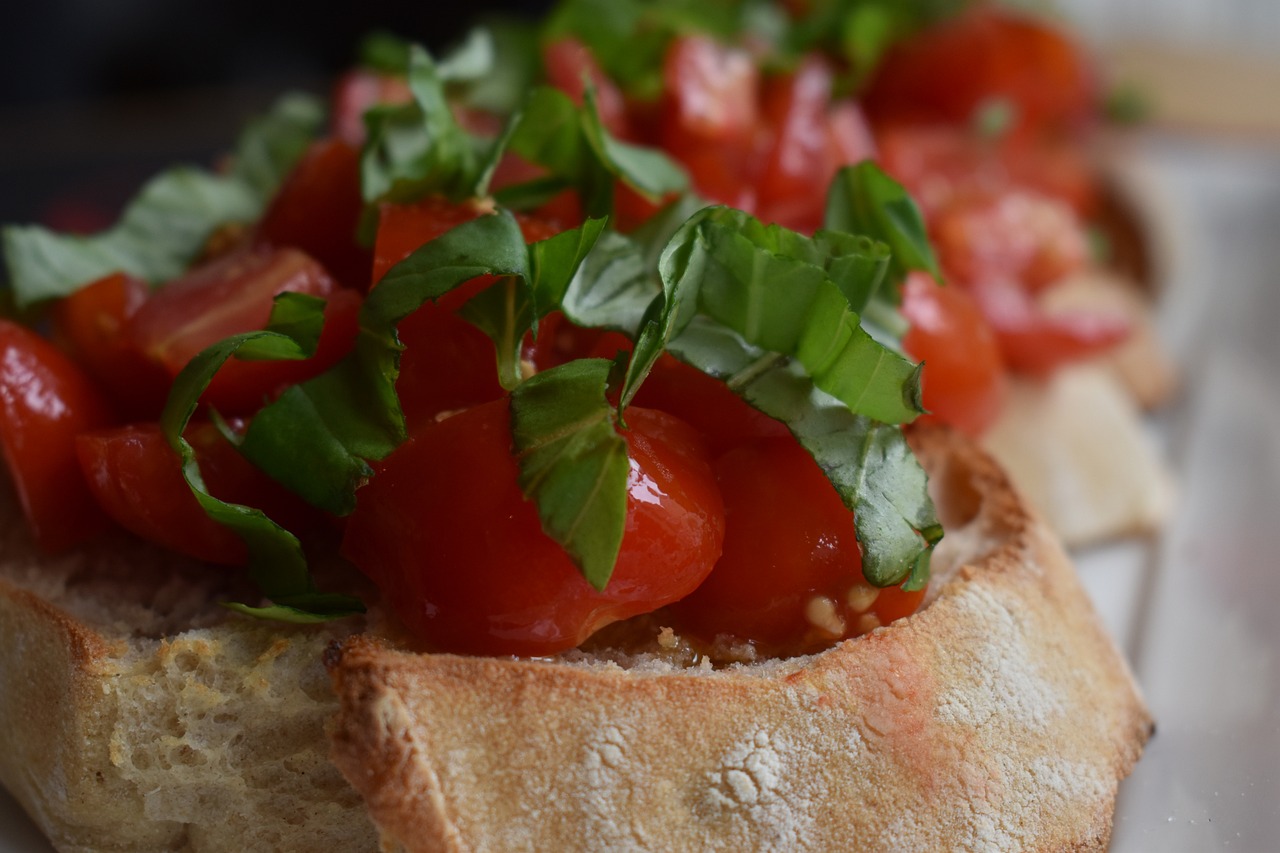 Bruschette al pomodoro su un tagliere, pronte per essere gustate, con ingredienti freschi e colorati.